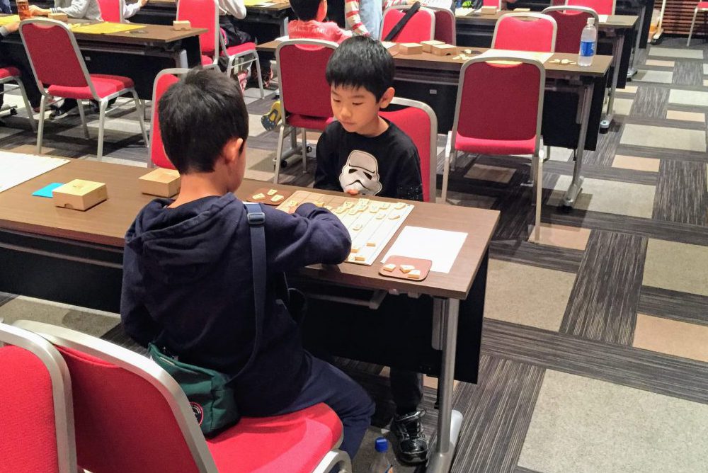子どもは将棋大会での対局を通じて仲良くなる